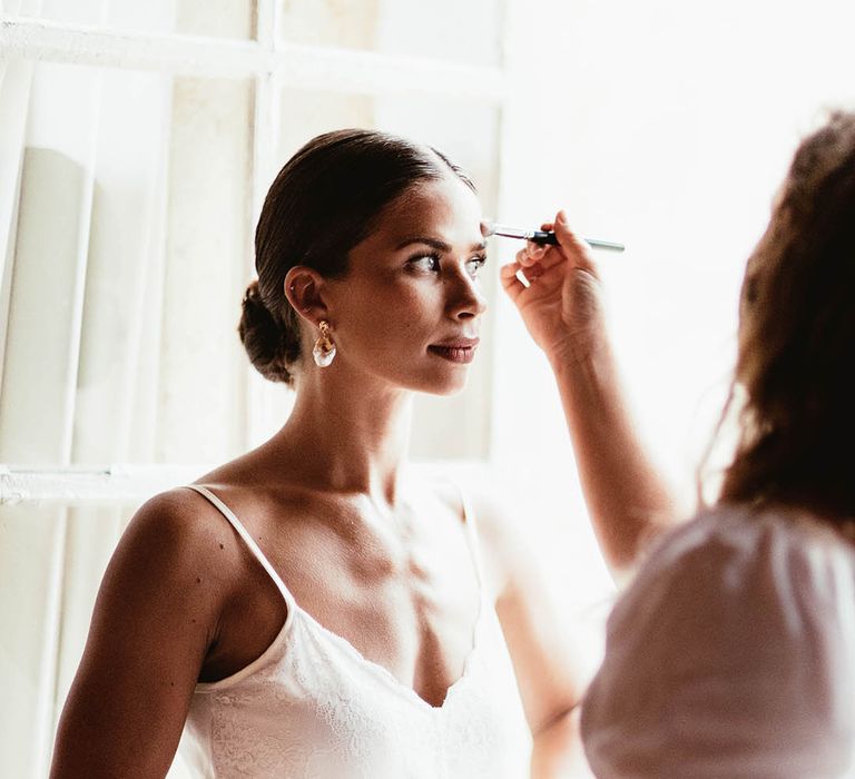 Bride has her makeup done on the morning of her wedding day