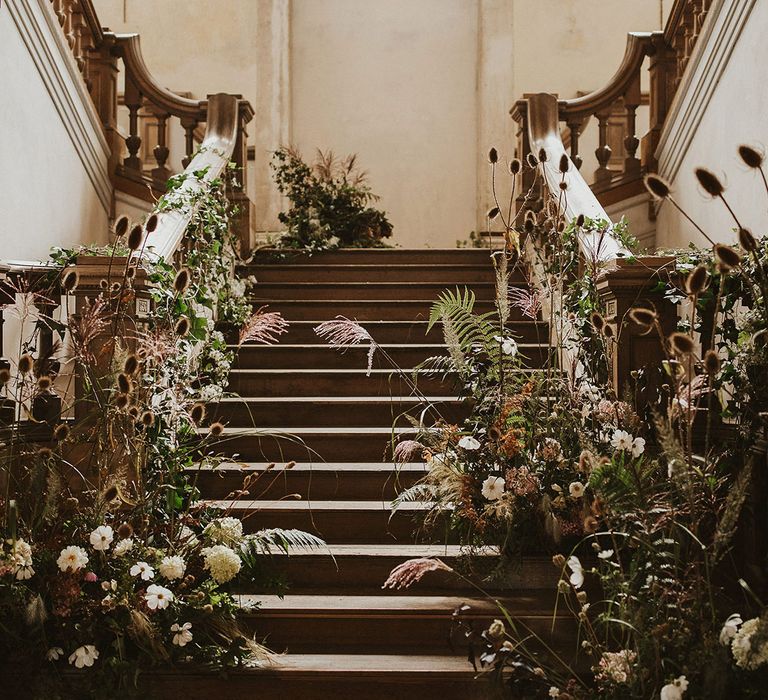 Rustic staircase complete with floral installation throughout bannisters 