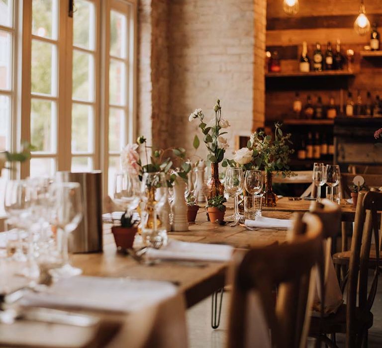 Wooden wedding tables with foliage and wild flower decor