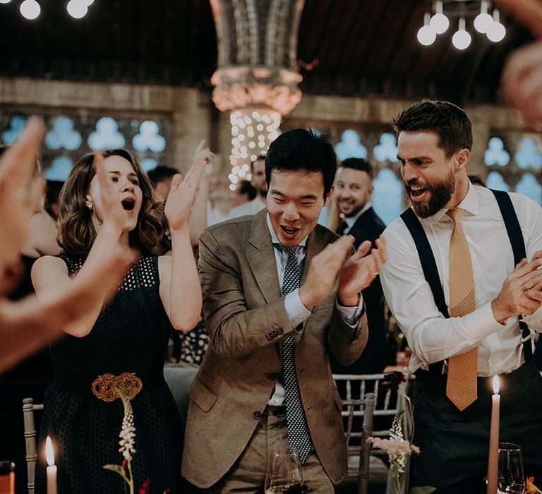 Wedding guests clap and dance during reception