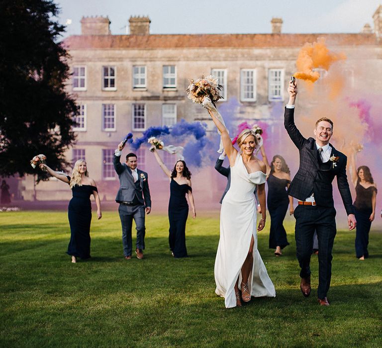 Bride, groom, bridesmaids and groomsman participate in smoke bomb photoshoot