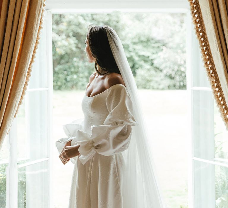 Bride in Emma Beaumont wedding dress wearing tiara crown and veil for church wedding ceremony 