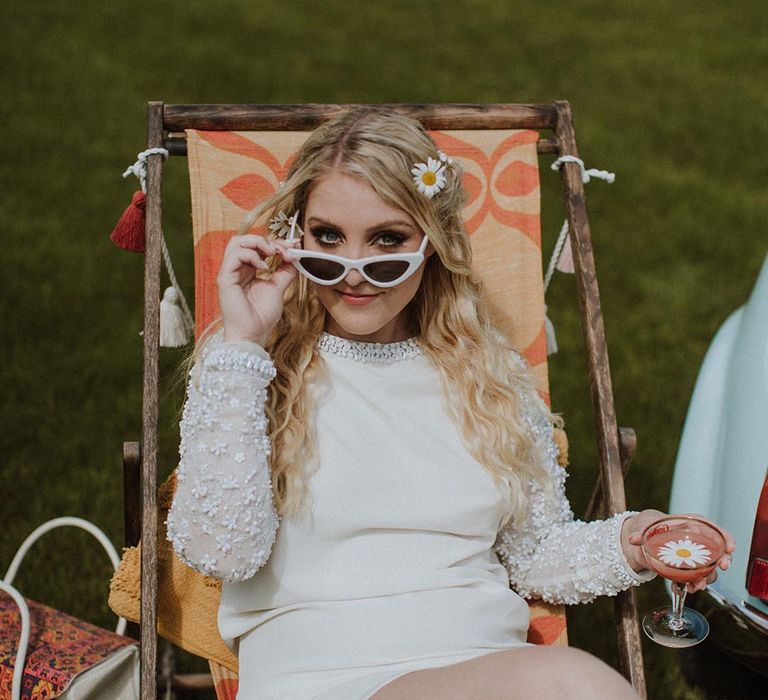 Sixties wedding inspiration with LGBTQI+ bride in a short wedding dress and white retro sunglasses 