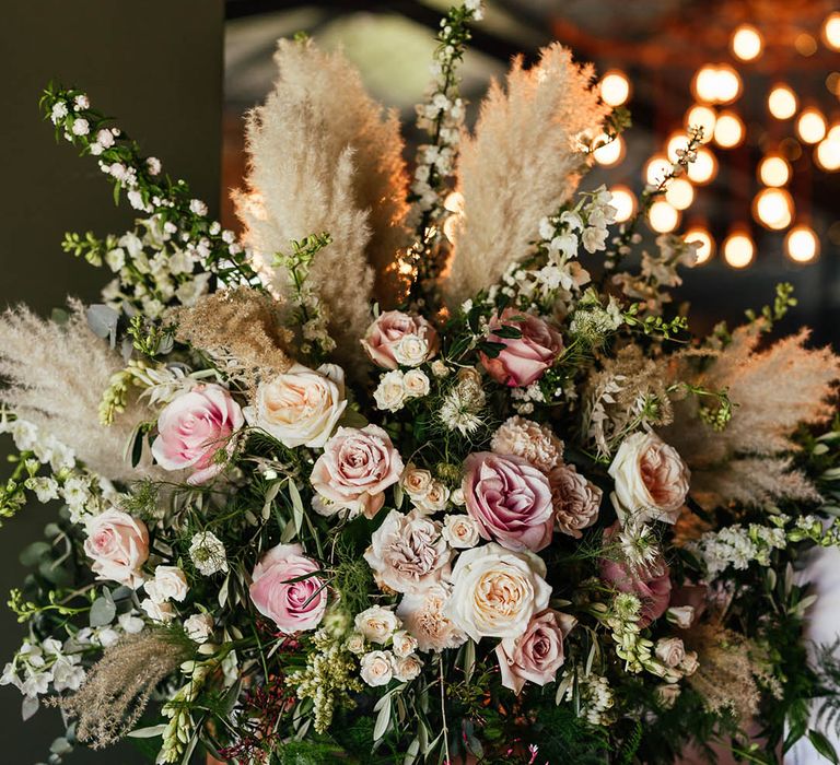 Pink and white roses with dried grass wedding flower decor 