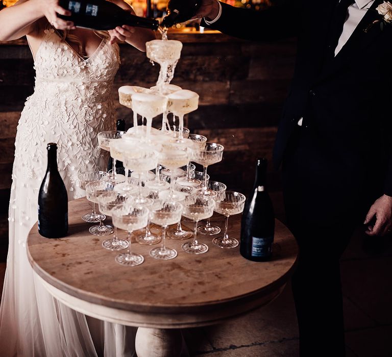 Bride and groom pour Prosecco for a Prosecco tower 