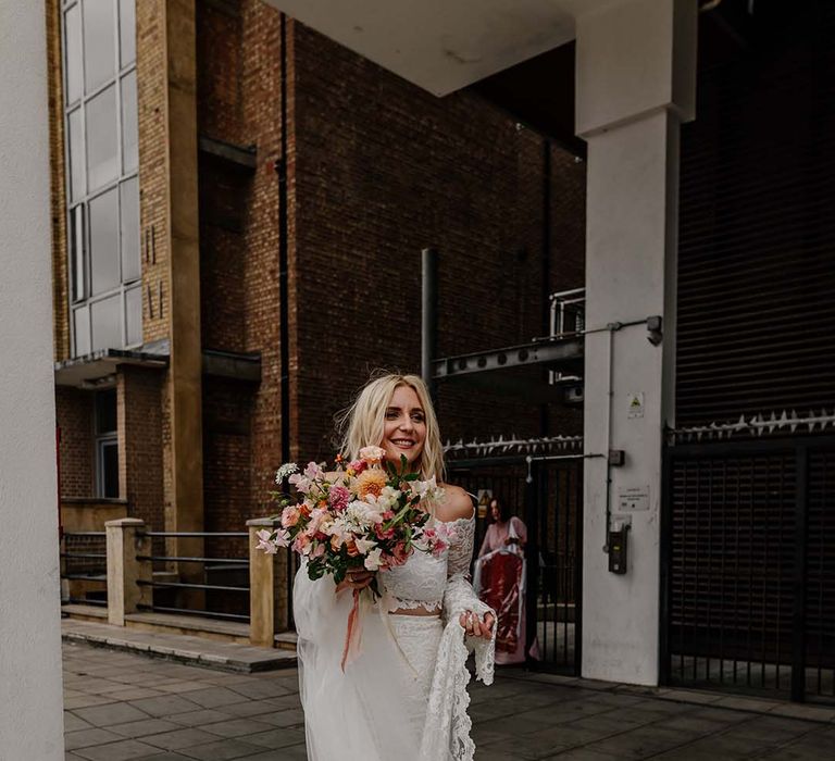 Bride in lace boho two piece and bright mixed floral wedding bouquet