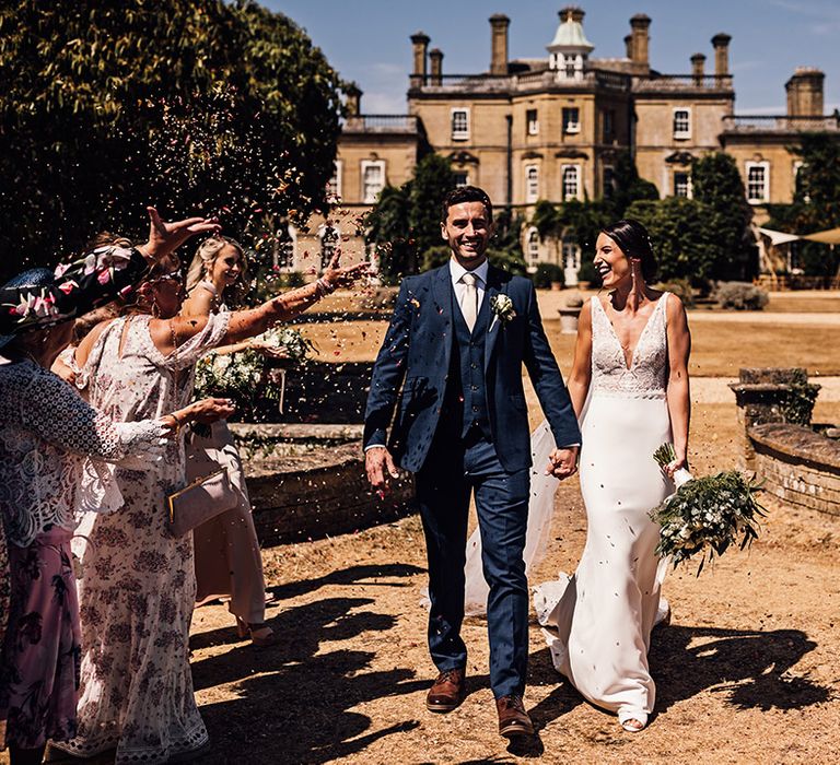 Bride and groom have a confetti exit after their outdoor wedding ceremony 