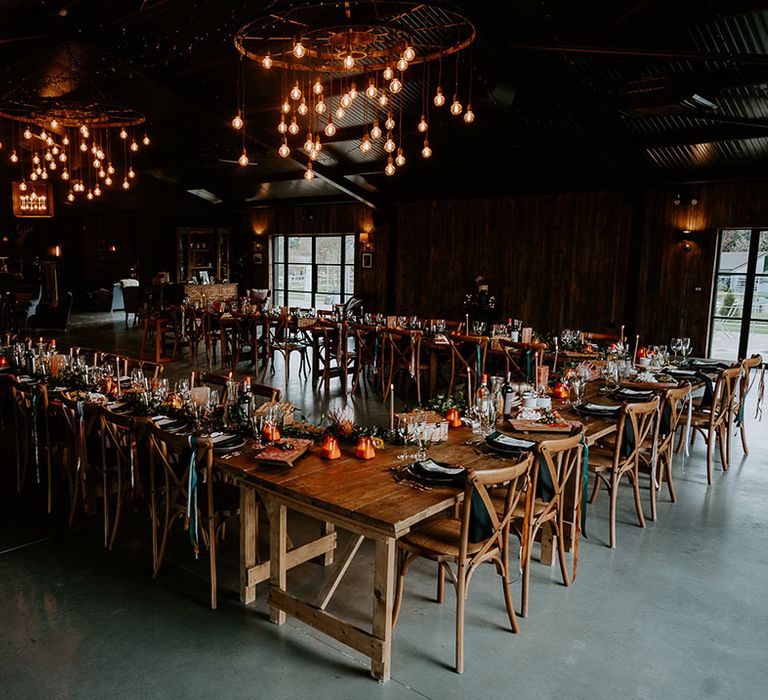 Wedding tables arranged in a U-shape in the reception room for rustic wedding at Silchester Farm 