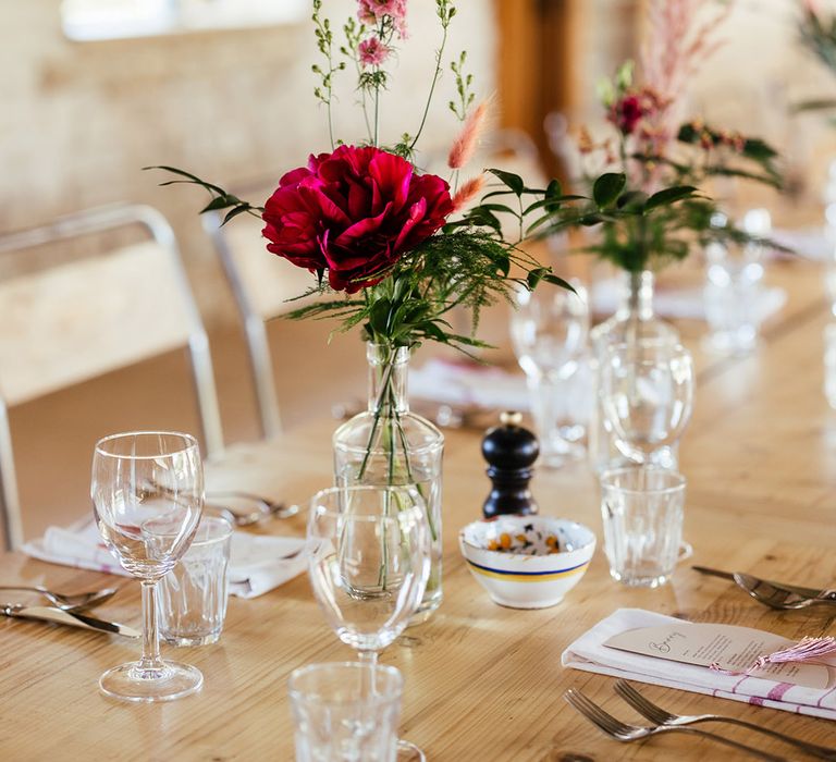 Large red garden rose floral arranagement on neutral boho wedding tablescape 