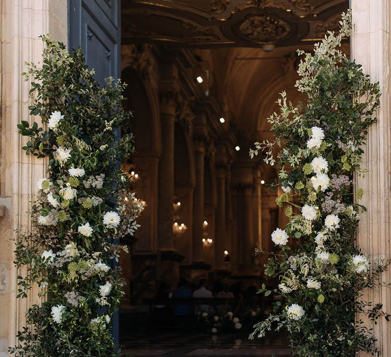 foliage and white column flower at church entrance 