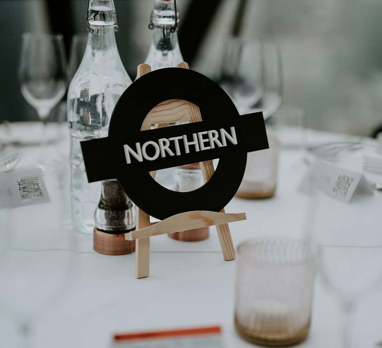 Alternative wedding table numbers - London tube station wedding table number on classic white wedding tablescape 