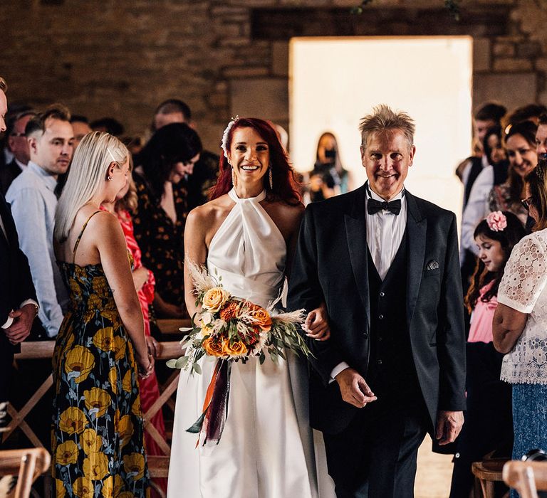 Bride in halter neck Halfpenny London with father of the bride in black tuxedo walking down the aisle