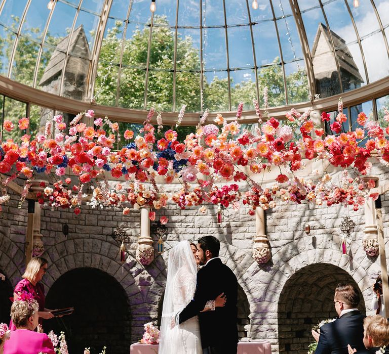 Glasshouse wedding venue in the Cotswolds with the bride na groom sharing their first kiss as a married couple 