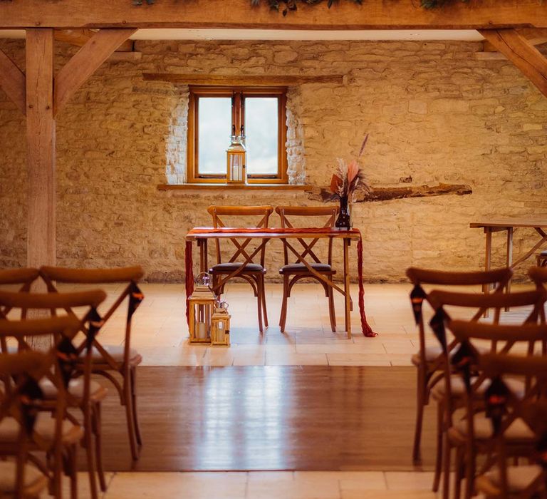 Kingscote Barn Tetbury wedding venue reception room with fairy lights, festoon lighting and exposed brick