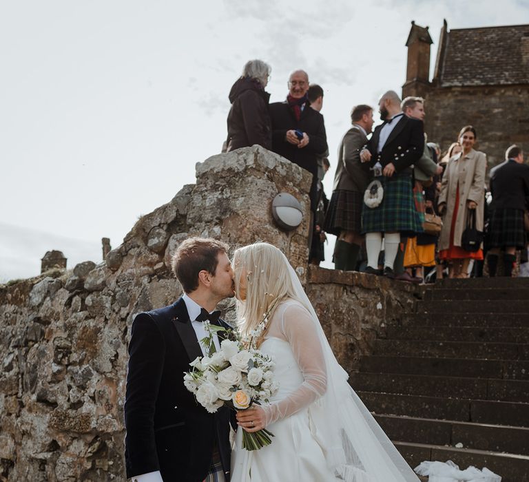 The bride and groom share an intimate kiss together after their confetti exit 