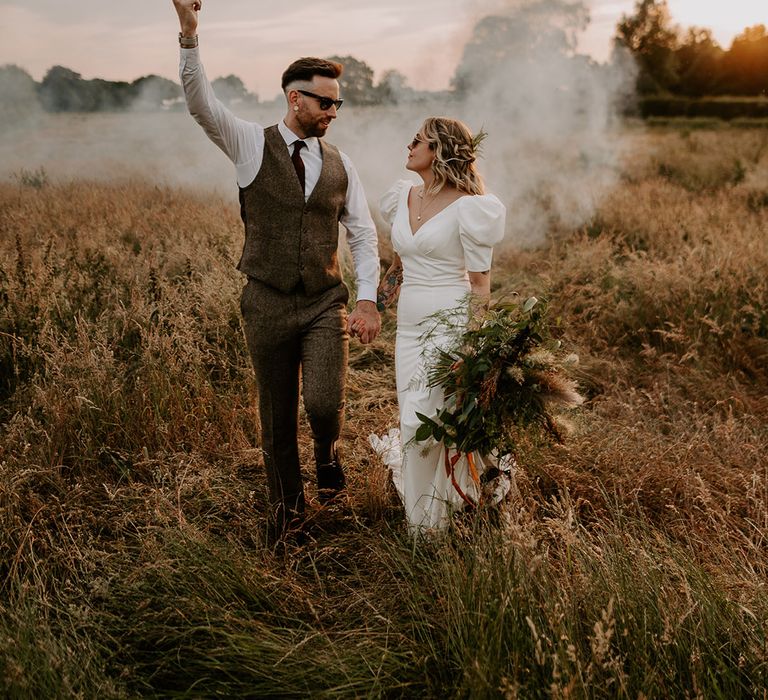 Grey smoke flare being waved by groom for fun wedding couple portrait 