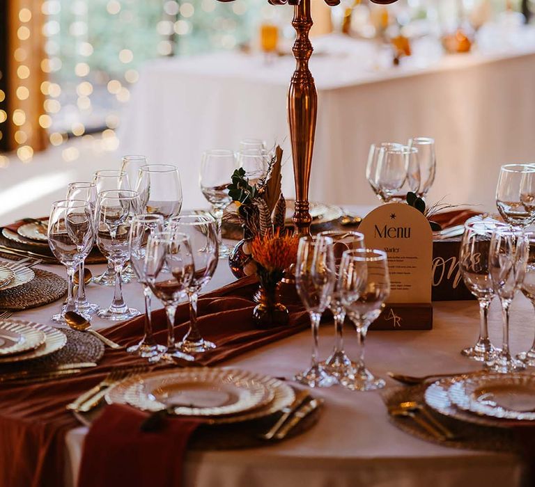 Autumnal theme wedding tablescape with tall candelabra with orange table decor for boho theme 