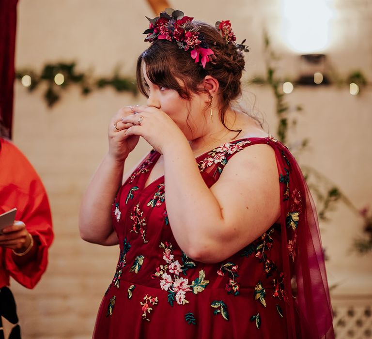 Bride drinking at wedding ceremony in red wedding dress with floral embroidery 