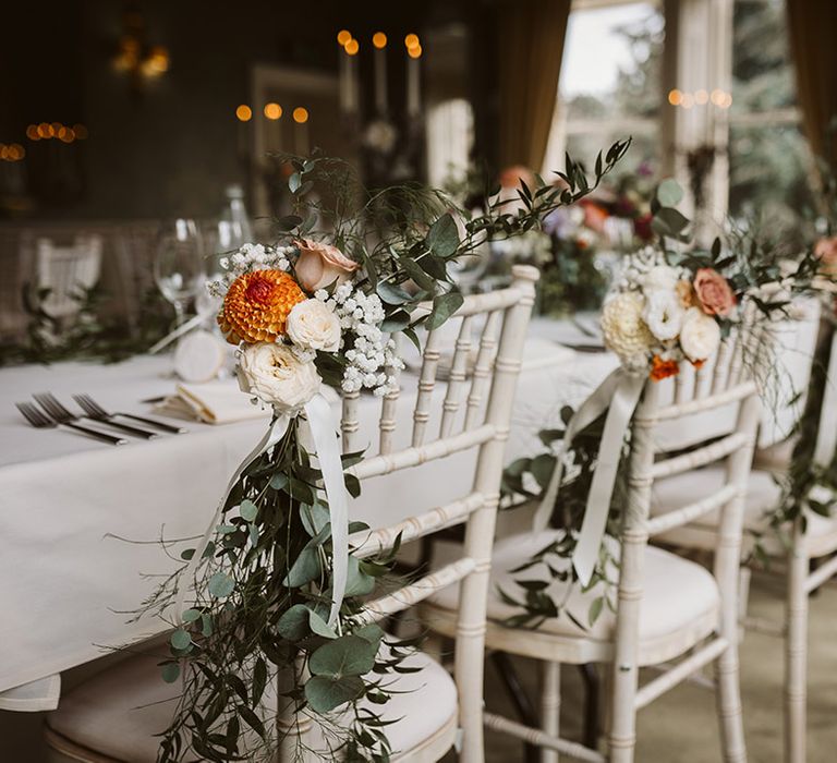 Traditional and elegant wedding tablescape at Bowcliffe Hall with autumnal flowers decorating the chairs 