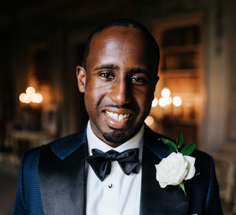 Stylish groom in navy tuxedo with black lapel 