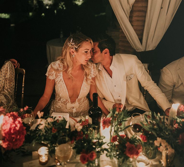 Bride and groom kissing at evening reception 