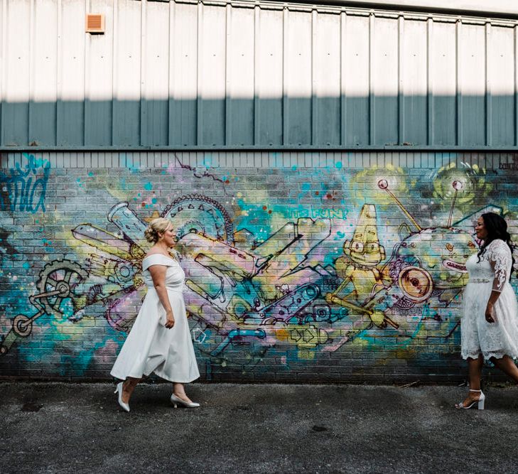 Striking wedding photography in the heart of Liverpool, graffiti wall art and happy brides