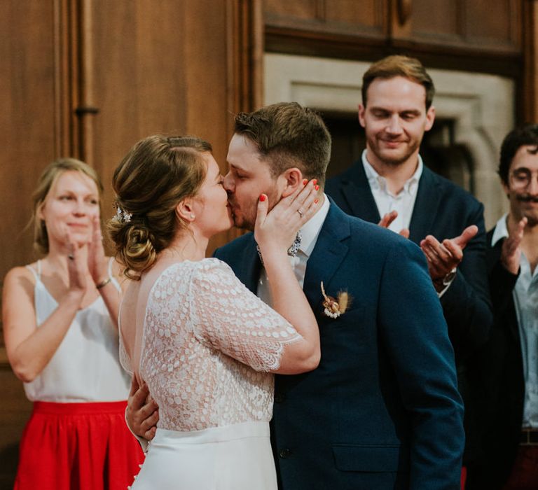 Bride kissing her groom with orange wedding nail polish