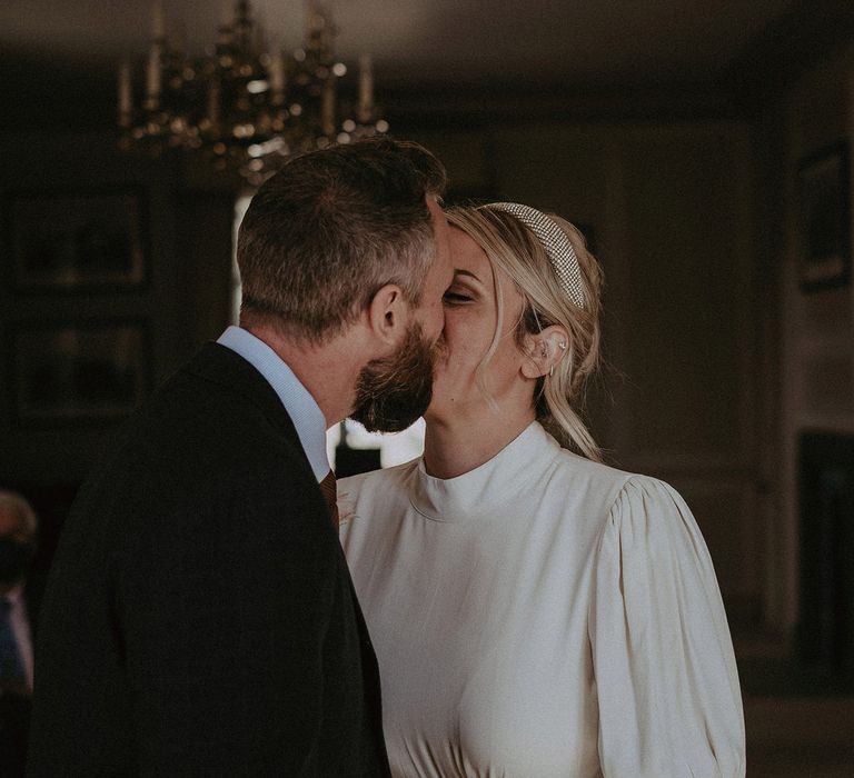 Bride and groom kissing at intimate micro wedding 