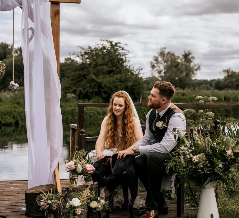 Bride & groom during wedding ceremony in front of river