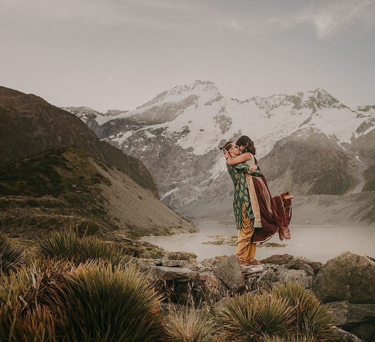 The bride and groom are elated after saying their vows on top of Mount Cook