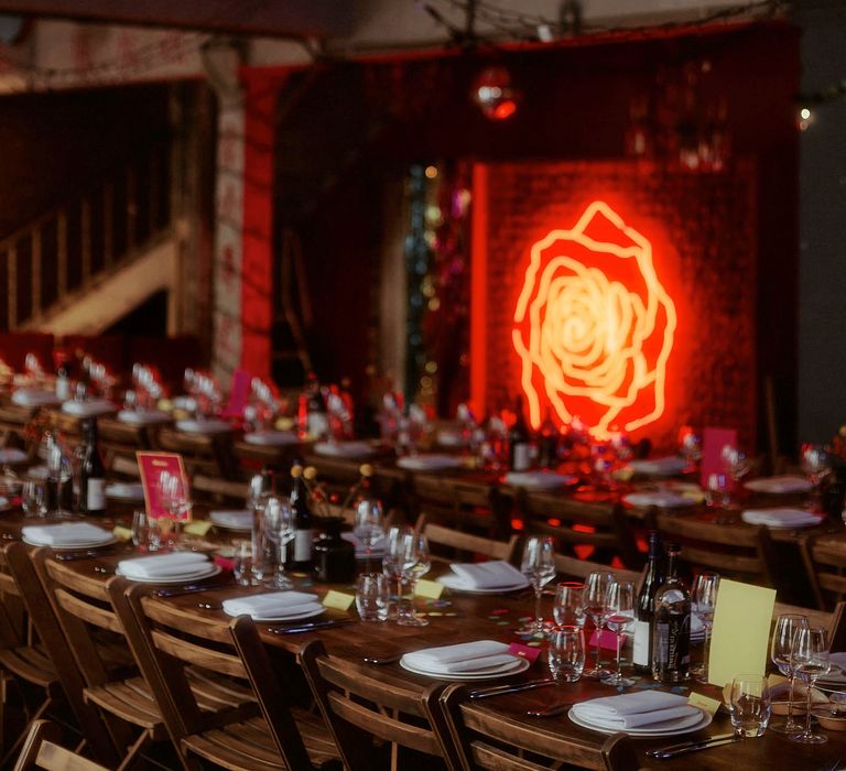 Industrial wedding reception decor with gold disco ball and rose neon sign 