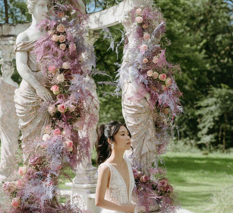 Bride sits with dark hair pulled back into a high ponytail 