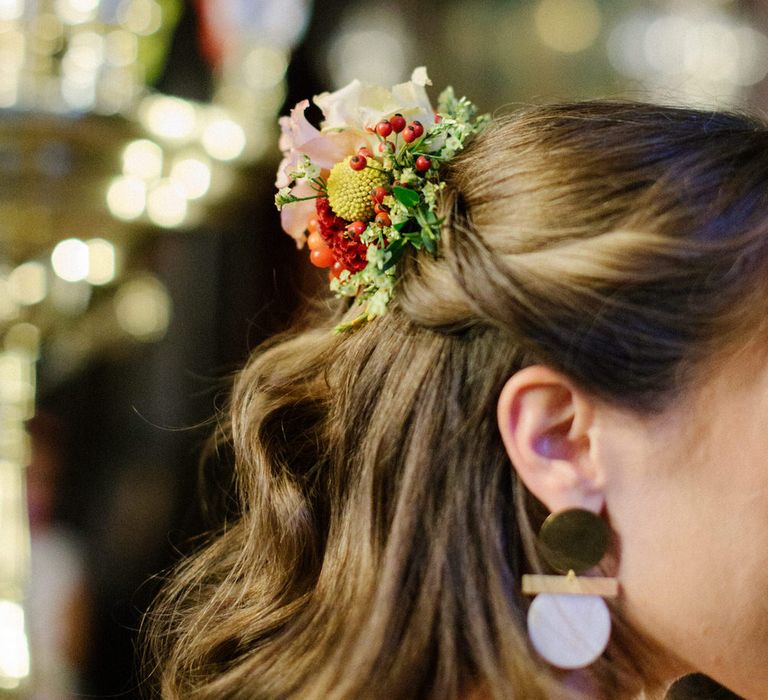 The bride wore berries, daisies and carnations in her wavy relaxed half updo