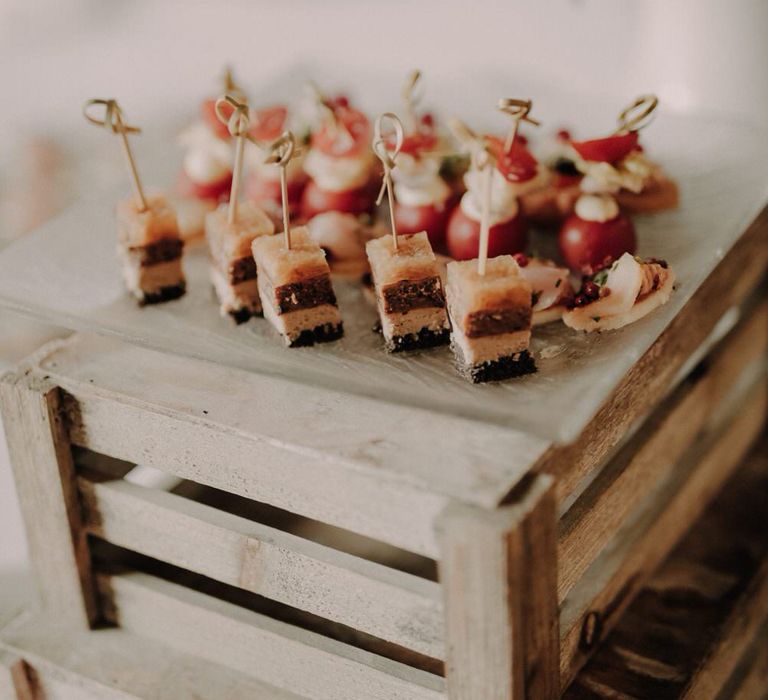 A plate of layered hors d'oeuvres on cocktail sticks