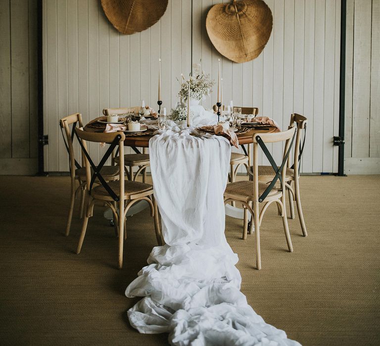 Bohemian wedding reception decor at Primrose Hill Farm with bamboo fans, natural linen table cloth and taper candles 