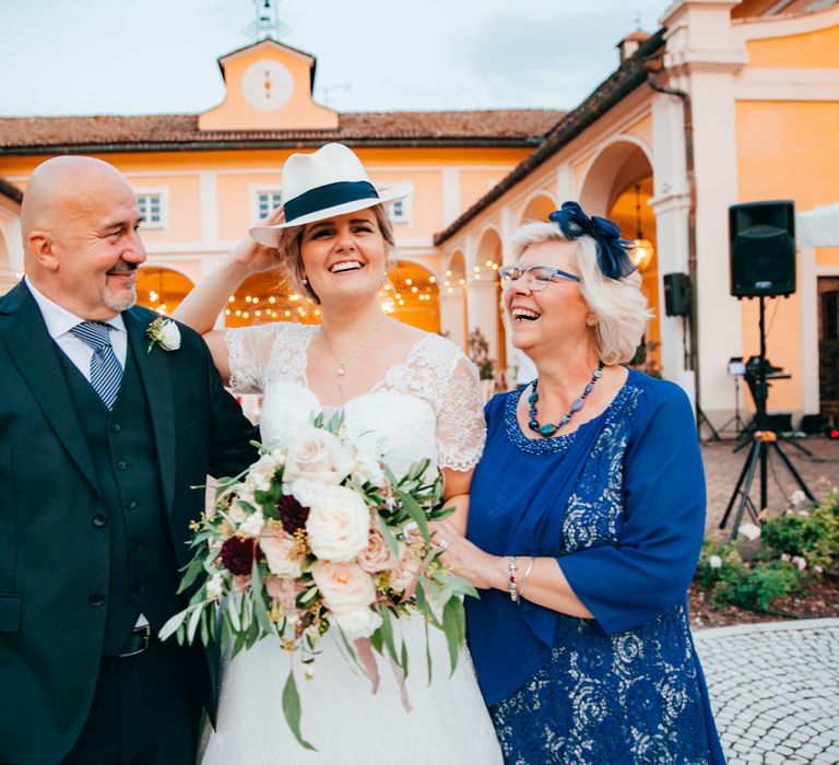 The bride with her parents, wearing her fathers white Italian hat