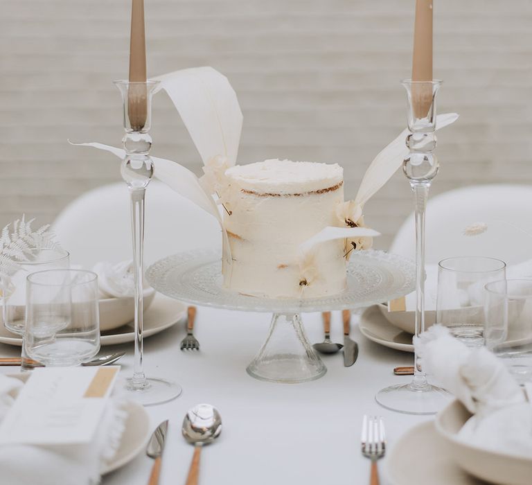 Tapered candles and mini iced white wedding cake