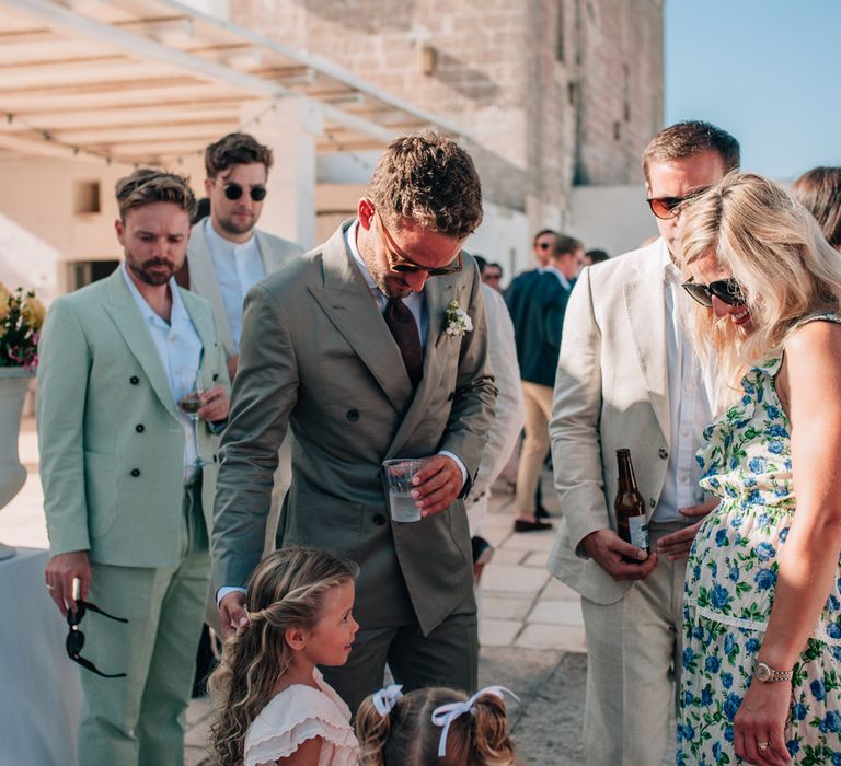 The groom with guests and two small flower girls