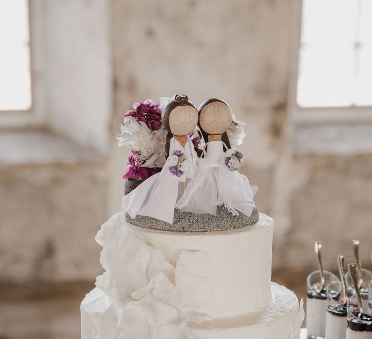 Two tier iced wedding cake with wooden cake toppers 