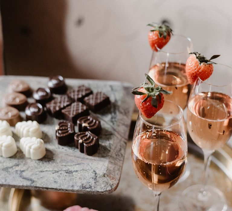 Praline chocolates and blush champagne with a strawberry garnish