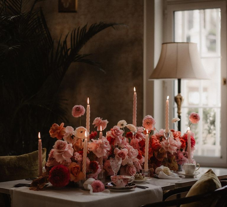 Luxe pink and peach wedding flowers tablescape at Amadria Park Hotel, with tapered candles and palm trees