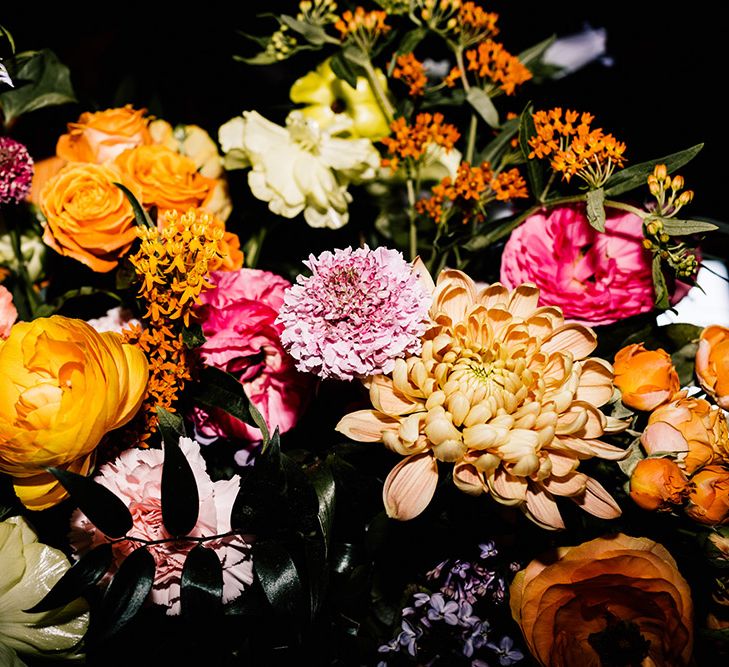 Colourful wedding flowers including dahlias, roses and ranunculus 