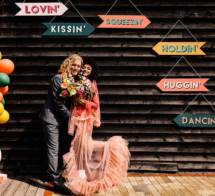 Colourful balloon installation and Lovin, Squeezin', Kissing', Holdin' Huggin' signs 