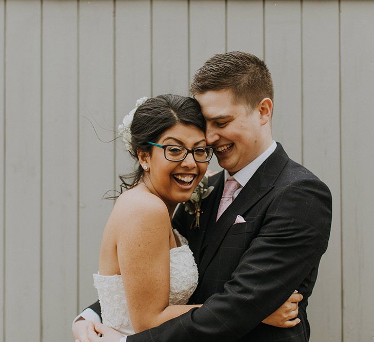 A bride and grooms hug for wedding portrait.