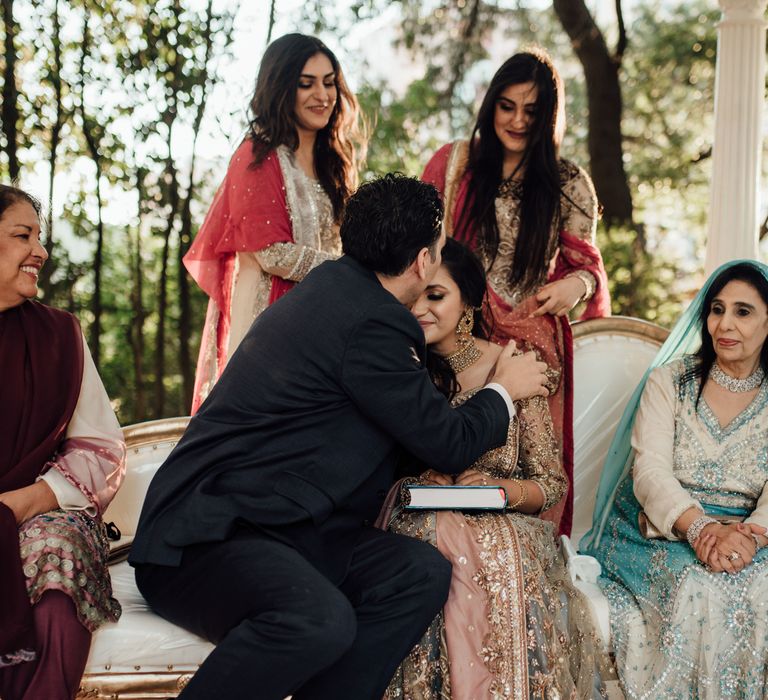 Groom kisses bride on her forehead during wedding ceremony