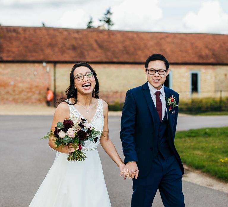 Bride & groom walk together outdoors on their wedding day