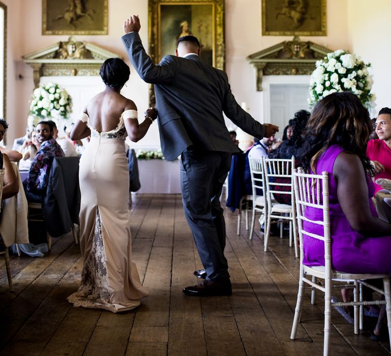 Wedding guests dance together on wedding day in stately room