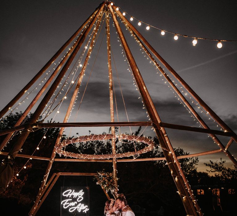 Naked tipi decorated in fairy lights with neon happily ever after sign at The Secret Garden Kent 