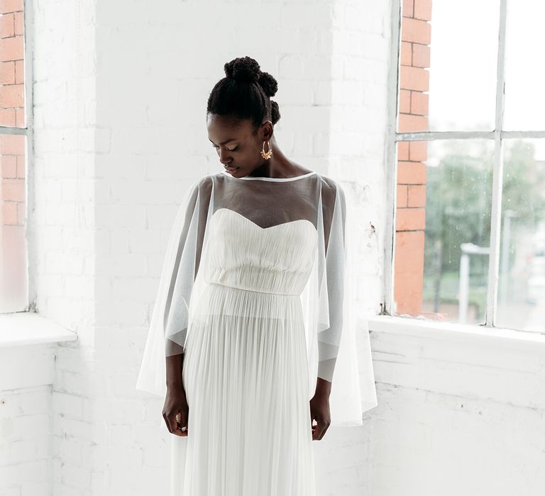 Black bride in a strapless wedding dress with pleat design wearing a sheer bridal cape by Rebecca Anne Designs