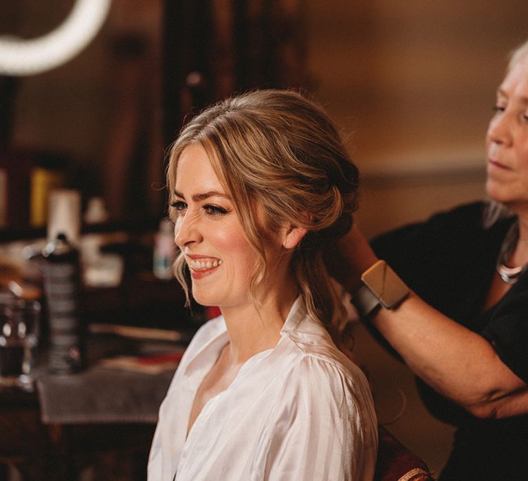 Bride on the wedding morning having her hair down into a pinned bridal up do 